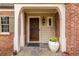 Inviting front entrance with stone flooring, brick facade, and wooden door detail at 883 Wildwood Ne Rd, Atlanta, GA 30324