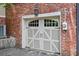 Garage with carriage doors and brick exterior, complemented by a stylish lantern at 883 Wildwood Ne Rd, Atlanta, GA 30324