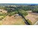 Expansive aerial view showcases a modern home nestled within a serene landscape of fields and lush forest surroundings at 85 Carroll Slough Rd, Kingston, GA 30145
