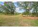 Expansive backyard featuring a well-manicured lawn, mature trees, and a seating area with fire pit at 85 Carroll Slough Rd, Kingston, GA 30145