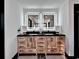 Double vanity with wooden cabinets, black countertop and LED-lit mirrors in a bright modern bathroom at 85 Carroll Slough Rd, Kingston, GA 30145