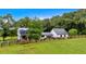 Charming white farmhouse with black roof, surrounded by vibrant green lawn and a rustic wooden fence at 85 Carroll Slough Rd, Kingston, GA 30145