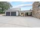 Charming home featuring a three-car garage and covered patio area with a stone facade and black trim at 85 Carroll Slough Rd, Kingston, GA 30145