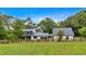 Beautiful modern farmhouse with black metal roof and white siding surrounded by lush greenery and a wooden fence at 85 Carroll Slough Rd, Kingston, GA 30145