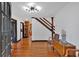 Elegant foyer with hardwood floors, staircase, modern light fixture, and a glimpse of the kitchen, showcasing classic design at 85 Carroll Slough Rd, Kingston, GA 30145