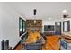 Well-lit living room boasts a stone fireplace, long dining table and wood floors at 85 Carroll Slough Rd, Kingston, GA 30145