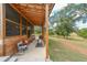 Enjoy the outdoors in this cozy screened-in porch with wood beams and a comfortable seating area at 85 Carroll Slough Rd, Kingston, GA 30145