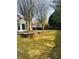 Spacious backyard with lawn, mature trees, patio, and brick retaining wall at 2520 Legend Mill Run, Dacula, GA 30019