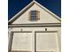 Close up of the two-car garage showcasing decorative shutters and clean white garage doors at 2520 Legend Mill Run, Dacula, GA 30019