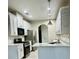 Well-lit kitchen featuring stainless steel appliances, white cabinets, and sleek countertops, offering a modern cooking space at 2520 Legend Mill Run, Dacula, GA 30019