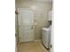 Functional laundry area with a washing machine, storage cabinet, and access door at 2520 Legend Mill Run, Dacula, GA 30019