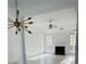 Open living room boasts light wood flooring, fireplace, and a unique chandelier design, blending comfort and style at 2520 Legend Mill Run, Dacula, GA 30019