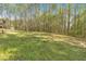 This backyard features a large grassy area and mature trees providing privacy and shade at 3800 Macland Rd, Hiram, GA 30141