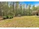 A backyard featuring a large grassy area, garden space, and a glimpse of the deck at 3800 Macland Rd, Hiram, GA 30141