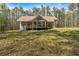 Charming home features a long covered porch and large front yard with beautiful mature trees at 3800 Macland Rd, Hiram, GA 30141
