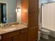Bathroom with wooden cabinets, granite countertops, and a shower-tub combo with curtain at 620 Glen Iris Ne Dr # 401, Atlanta, GA 30308