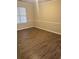 Bedroom featuring light walls, white baseboards, trim, and wood-look flooring at 6715 Roscommon Dr, Austell, GA 30168