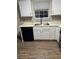 Kitchen featuring white cabinets, stainless steel sink, black dishwasher and neutral backsplash at 6715 Roscommon Dr, Austell, GA 30168