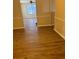 Living room featuring light walls, wood-look flooring, and a view of the adjacent room at 6715 Roscommon Dr, Austell, GA 30168