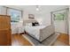 Comfortable bedroom with hardwood floors, a tufted headboard bed, and natural lighting at 3700 Sexton Woods Dr, Chamblee, GA 30341