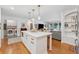 Bright open kitchen featuring an island with quartz countertop and stainless appliances leading to the living room at 3700 Sexton Woods Dr, Chamblee, GA 30341