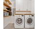 Laundry room complete with wooden shelves, countertops, and modern, front-load washer and dryer at 3700 Sexton Woods Dr, Chamblee, GA 30341