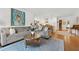 Open-concept living area with hardwood floors, a gray sofa and direct access to a modern, updated kitchen at 3700 Sexton Woods Dr, Chamblee, GA 30341