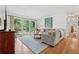 Bright living room featuring hardwood floors, a comfortable couch and large windows overlooking a lush yard at 3700 Sexton Woods Dr, Chamblee, GA 30341