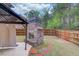 Fenced backyard featuring a brick fireplace and patio, ideal for outdoor living at 1633 Park Hollow Ln, Lawrenceville, GA 30043