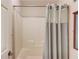 Well-lit bathroom featuring a shower with a shower curtain and neutral tile surround at 1633 Park Hollow Ln, Lawrenceville, GA 30043