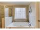 A tub with tile surround and decorative glass window, providing a relaxing and luxurious experience at 1633 Park Hollow Ln, Lawrenceville, GA 30043