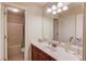 Well-lit bathroom featuring cherry cabinets, white countertop, large mirror, and a shower/tub combo for convenience at 1633 Park Hollow Ln, Lawrenceville, GA 30043