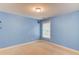 Cozy bedroom with blue walls, neutral carpet, and natural light from a window at 1633 Park Hollow Ln, Lawrenceville, GA 30043