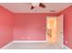 Bright bedroom with peach walls, carpet, and white trim, featuring a window and connecting door to the hallway at 1633 Park Hollow Ln, Lawrenceville, GA 30043