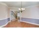 Elegant dining room featuring hardwood floors, chandelier, and adjacent stairway and foyer at 1633 Park Hollow Ln, Lawrenceville, GA 30043