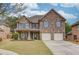 Charming two-story brick home with a well-manicured lawn and attached two-car garage at 1633 Park Hollow Ln, Lawrenceville, GA 30043