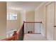 Upstairs hallway featuring wood railing, iron spindles, neutral carpet, and natural light illuminating the area at 1633 Park Hollow Ln, Lawrenceville, GA 30043