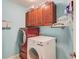 Bright laundry room with modern washer and dryer, and cherry storage cabinets at 1633 Park Hollow Ln, Lawrenceville, GA 30043