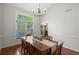 A dining room featuring hardwood floors, a large window, a decorative light fixture, and crown molding at 3450 N Cook Rd, Powder Springs, GA 30127