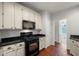Bright kitchen featuring ample cabinetry, black countertops, hardwood floors, and a view of the home's interior at 3450 N Cook Rd, Powder Springs, GA 30127