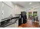 Modern kitchen with black countertops, stainless steel appliances, and hardwood floors at 3450 N Cook Rd, Powder Springs, GA 30127