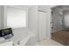 A bright bathroom featuring a soaking tub, a decorative window, and views into an adjacent bedroom at 3450 N Cook Rd, Powder Springs, GA 30127