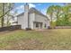 Backyard view of a two-story home featuring mature trees and partial wooden fence at 404 Foxwood Ct, Mcdonough, GA 30253