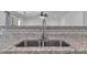 Close-up of double basin sink and granite countertops with tile backsplash at 404 Foxwood Ct, Mcdonough, GA 30253