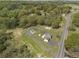 Expansive aerial view showcasing the property's layout, including the home, outbuildings, driveway, and surrounding greenery at 5125 Dahlonega Hwy, Cumming, GA 30028