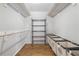 Walk-in closet featuring wood floors, wire shelving, and laundry bins at 5125 Dahlonega Hwy, Cumming, GA 30028