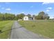 Charming home featuring a well-maintained driveway, lawn, and a picturesque setting with a lush tree line and blue sky at 5125 Dahlonega Hwy, Cumming, GA 30028