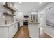 Charming kitchen boasts white cabinets, stainless steel appliances, and granite countertops at 5125 Dahlonega Hwy, Cumming, GA 30028
