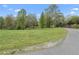 Expansive grassy lot with mature trees offers a tranquil setting and potential for various landscaping or building projects at 5125 Dahlonega Hwy, Cumming, GA 30028