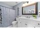 Well-lit bathroom with white vanity, stylish mirror, and patterned shower curtain at 5334 Lake View Clb, Atlanta, GA 30338